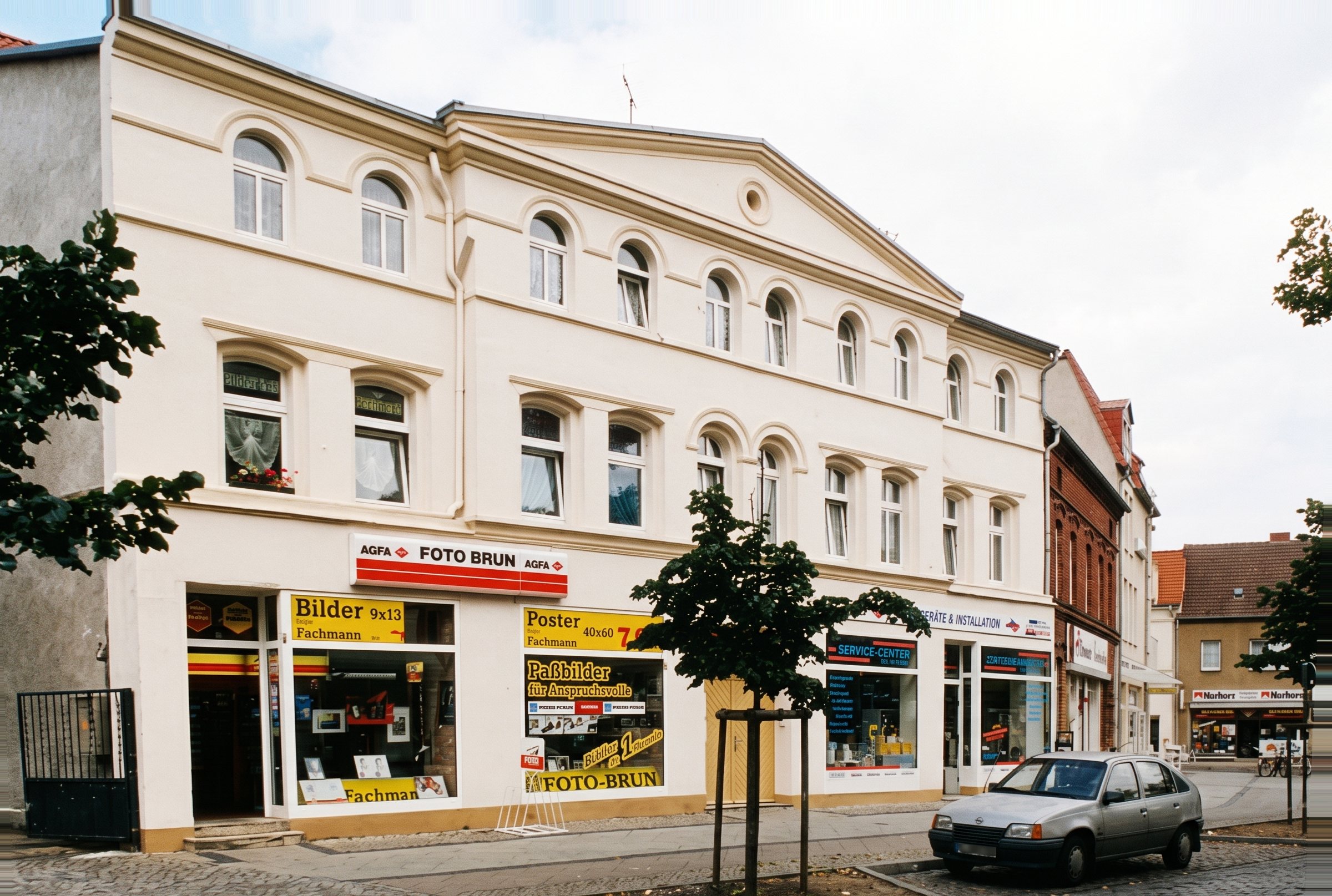Das frisch sanierte, helle Haus um 2000 mit dem Laden Foto-Brun: AGFA-Schild, gelbe Plakate für Bilder, Poster und Passbilder in den Schaufenstern