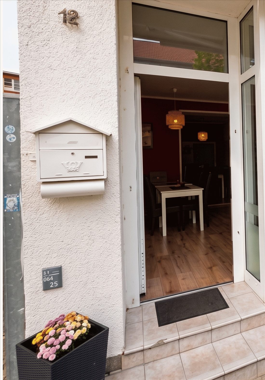 Der Eingang an der Straße mit der Hausnummer 12 und Stufen vor der offenen Tür
